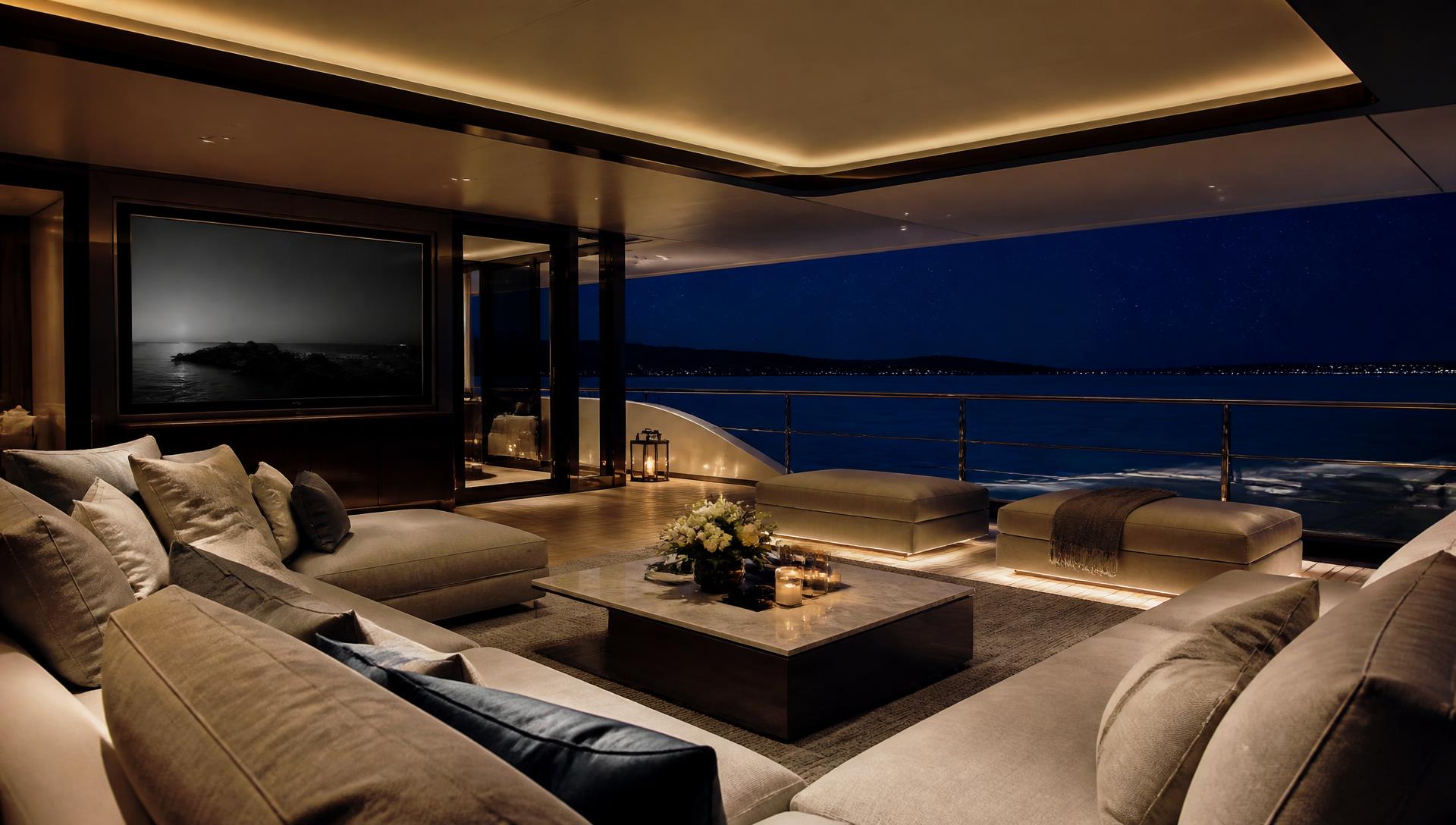 Superyacht upper deck lounge at night with warm concealed lighting and a starlit sea beyond the glass